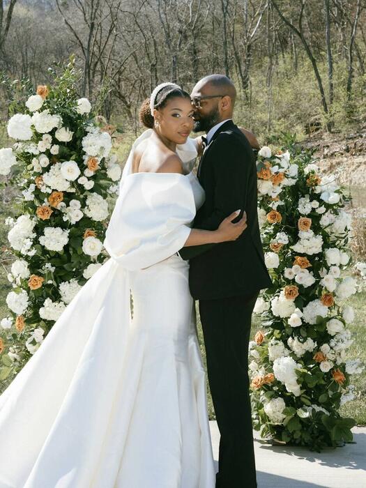 The couple under a floral arch